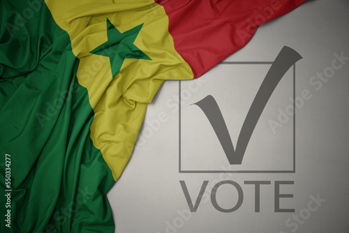 waving colorful national flag of senegal on a gray background with text vote. 3D illustration photo