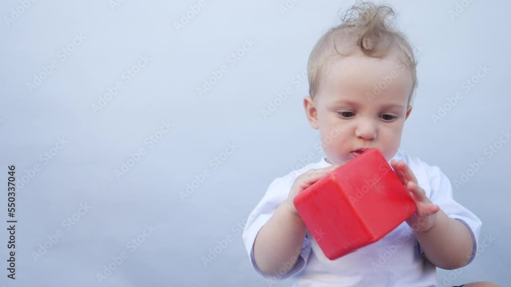 baby drooling bubbles on the lips a toddler play with a cube at home. little boy son portrait fun close-up. little baby playing at home. happy family stay home concept baby drooling bubbles on the lips a toddler play with a cube at home. little boy son portrait fun close-up. little baby playing at home. happy family stay home concept