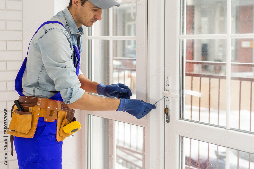 Construction worker installing window in house Construction worker installing window in house
