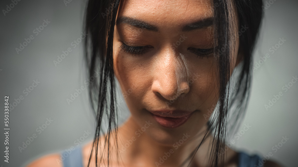 Extreme Close Up of the Face of a Asian Female Looking Down. Strong Young Woman Thinking and Contemplating, Fighting Against Mental Illness. She is Making Decisions to Improve her Wellness Extreme Close Up of the Face of a Asian Female Looking Down. Strong Young Woman Thinking and Contemplating, Fighting Against Mental Illness. She is Making Decisions to Improve her Wellness
