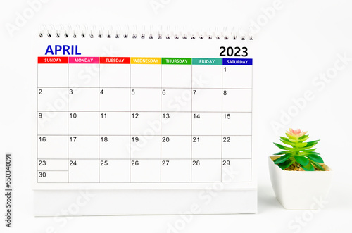 The April 2023 Monthly desk calendar for 2023 year with plant pot isolated on white background.