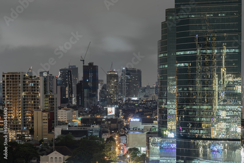 Skyscrapers in the business district of Bangkok city at night under Sprinkling rain. Rainy season, No focus, specifically.