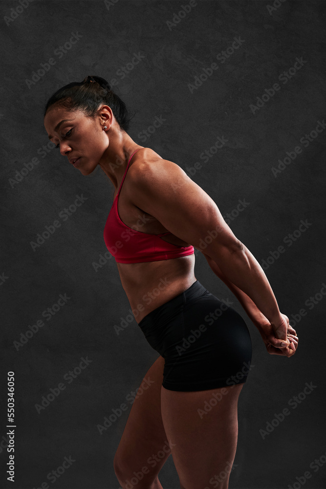 Fit sportswoman stretching body on black background Fit sportswoman stretching body on black background