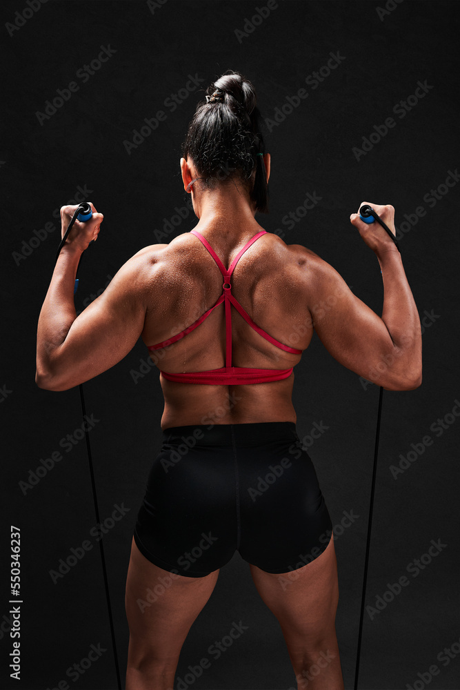 Anonymous strong sportswoman exercising with TRX Anonymous strong sportswoman exercising with TRX