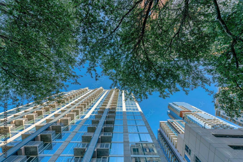 Apartments withbalconies and glass windows facade reflecting modern buildings