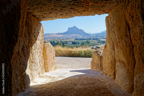 Interior of the megalithic monument Dolmens in Antequera with the natural monument The Lovers' Rock in the background. Touristic travel to Spain. Historic interest and Unesco World Heritage Site. 