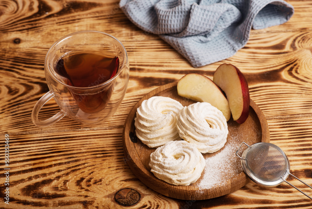 Handmade marshmallow. Natural sweetness. Apple zephir and cup of tea in wood surface