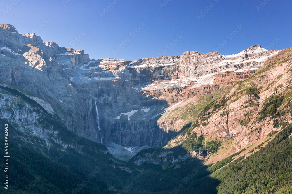 Aerial view with Gavarnie town and the famous waterfall on Pyrenees Orientals mountains at France Spain border