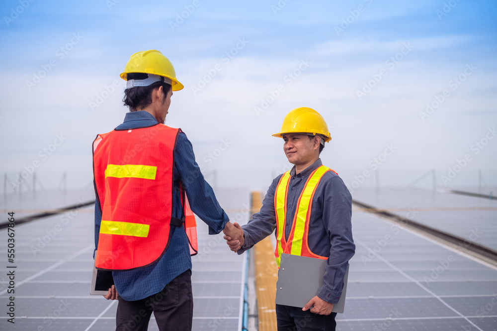 Workers shake hand trust in project install solar panel solar power energy on factory roof Workers shake hand trust in project install solar panel solar power energy on factory roof