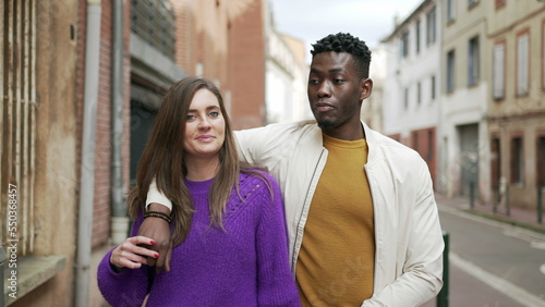 Interracial couple walking together in street. Millennial diverse modern couple