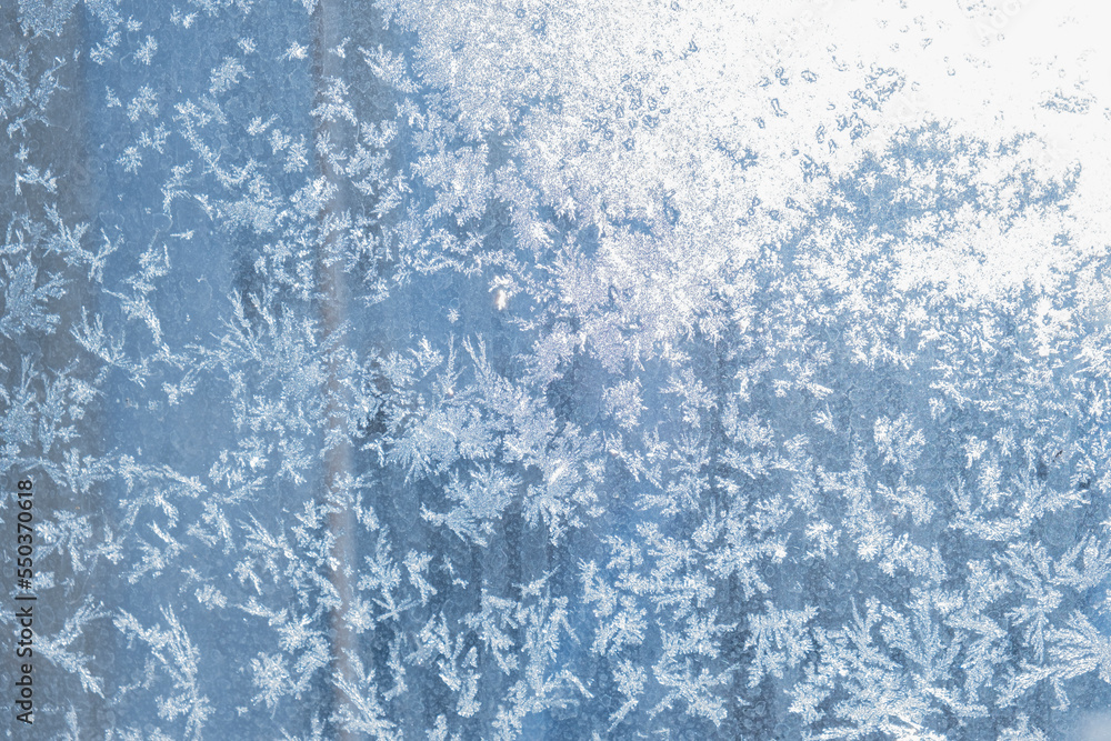 Beautiful blue patterns left by frost on the window create the atmosphere of a New Year, Christmas holiday or other event. copy space Beautiful blue patterns left by frost on the window create the atmosphere of a New Year, Christmas holiday or other event. copy space