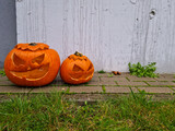 Two carved pumpkin heads stand in the corner. Jack o'lantern is a carved lantern. Evil grimace. Celebrating autumn trick or treat festival. Orange pumpkin.