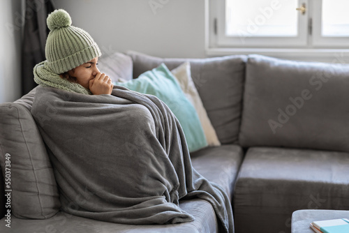 Energy Crisis. Portrait Of Woman Covered In Warm Blanket Sitting On Couch