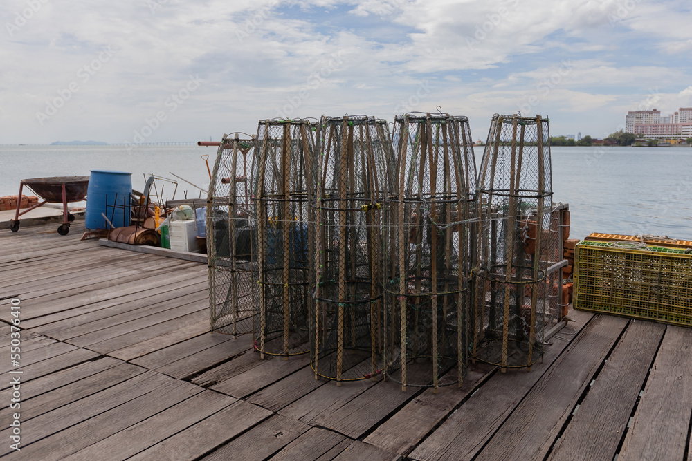 Naklejka premium Nets for crabs and fishes on the pier. Fishing village in Malaysia