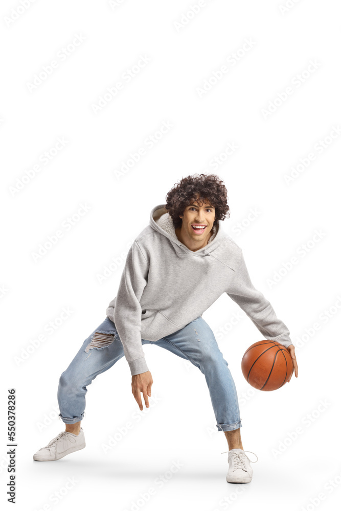 Young man in jeans playing basketball