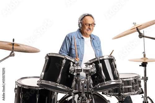 Mature man with headphones playing drums