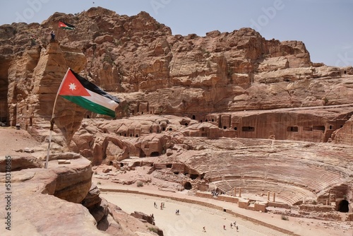 Jordan flag on viewpoint, ancient Theatre in background, Petra, Jordan. Petra is ancient Nabataean city,  considered one of seven new wonders of world and is  world heritage site.