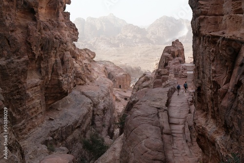 Amazing views on tourist trail to High Place of Sacrifice in ancient Nabataean city of Petra, Jordan. Petra is considered one of seven new wonders of world. Silhouettes of people on trail.