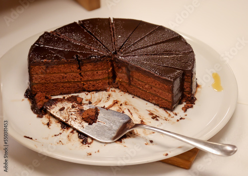 Eine angeschnittene Schoko Creme Torte bei der schon Stücke fehlen. photo