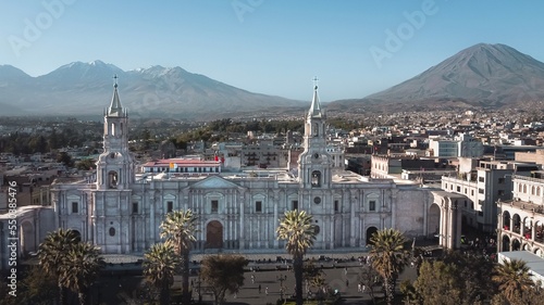 aerial photo with drone of the beautiful plaza de armas with the cathedral of the city of Arequipa, Peru. In the background the three volcanoes: the Chachani, the Pichu Pichu and the Misti. Tourism.