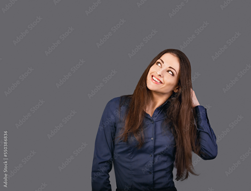 Thinking business woman in blue shirt looking up on grey background with empty copy space for text. Closeup Thinking business woman in blue shirt looking up on grey background with empty copy space for text. Closeup