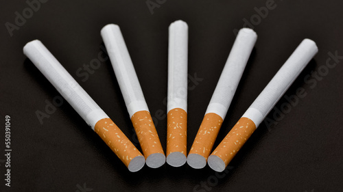 Cigarettes and cigarette butts on a black background. photo