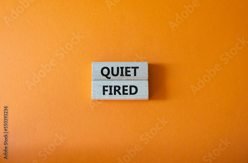 Quiet fired symbol. Concept word Quiet fired on wooden blocks. Beautiful orange background. Business and Quiet fired concept. Copy space