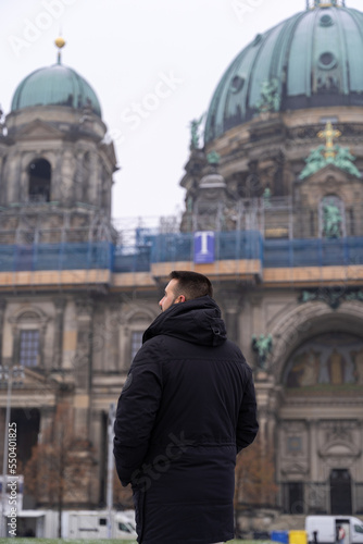 Unrecognizable young male tourist in the park in front of the Berlin Cathedral with snow all over the ground © Jenni Ventura Martil