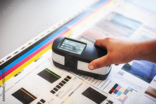 Fotografie X-Rite handheld spectrophotometer verify color patches, modern press shop prepress department