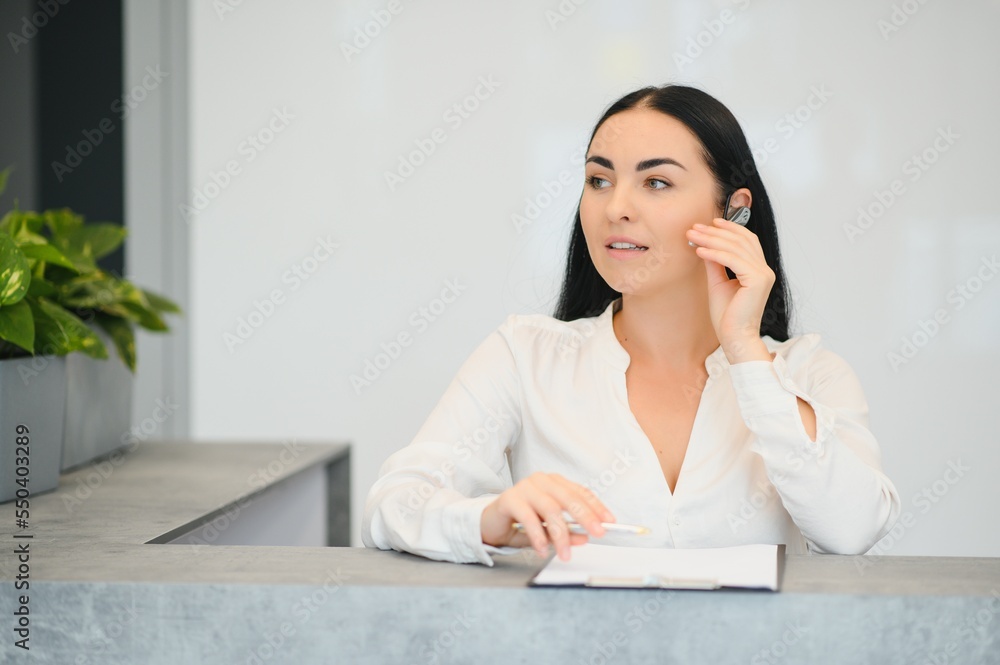 Portrait of beautiful receptionist near counter in hotel Portrait of beautiful receptionist near counter in hotel