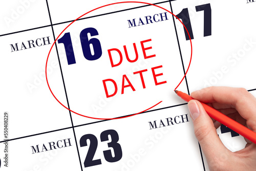Hand writing text DUE DATE on calendar date March 16 and circling it. Payment due date