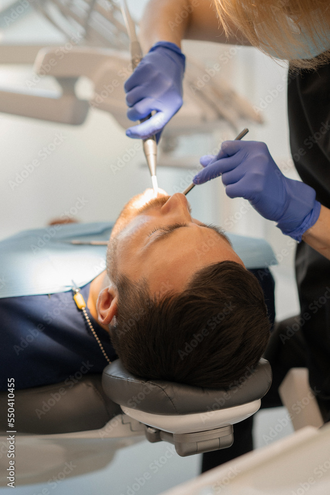 Fototapeta premium Young man at the dentist. Dentist woman. Dental office.