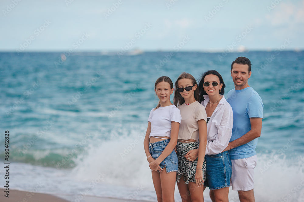 Happy family posing on the beach during summer vacation