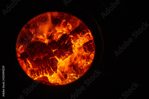 wood burns in the fireplace Heat energy heap closely, red and yellow, thermal energy at the fuel point during the night / lights on a black background flames Campfire circle. stove