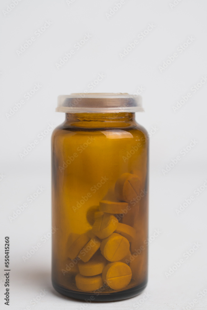 A small glass bottle of pills A small glass bottle of pills