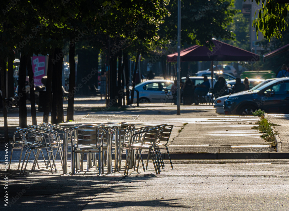 Empty metal chairs on a street terrace in a city bar at sunset. Empty metal chairs on a street terrace in a city bar at sunset.
