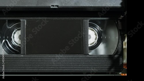 Old video recorder inside close-up, VHS. Retro player in neon red light, vintage video cassette broadcasting, audio tape. 