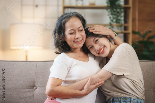 Expression of love between a mother-daughter who takes care of each other, a mother-daughter Asian woman who spends her vacation in the living room happily and warmly expressing her love at home.