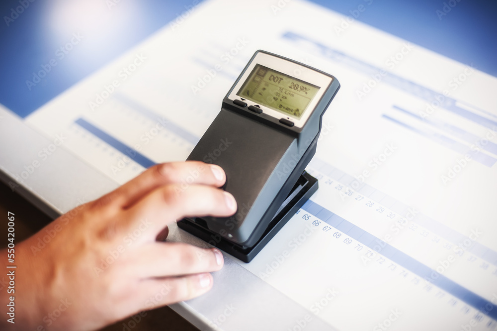 X-Rite handheld spectrophotometer verify color patches, modern press shop prepress department. X-Rite handheld spectrophotometer verify color patches, modern press shop prepress department.