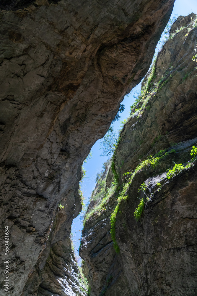 Beautiful curved crevice in canyon in sunny weather. Wide angle view of amazing sandstone formations in Salta gorge in mountains of Dagestan, Russia. Beautiful curved crevice in canyon in sunny weather. Wide angle view of amazing sandstone formations in Salta gorge in mountains of Dagestan, Russia.