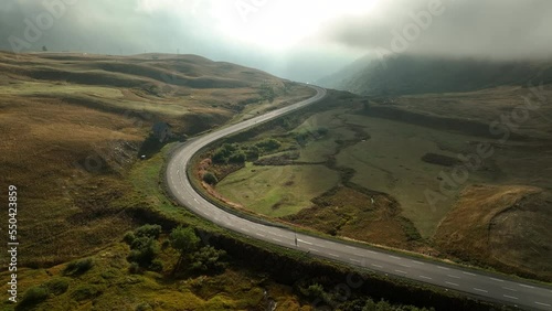 Winding road in french alps mountains mystical moody morning light aerial shot 
