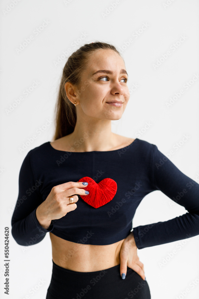 Caring for the heart, cardio training. A young woman takes care of health and holds a red heart in her hands. Caring for the heart, cardio training. A young woman takes care of health and holds a red heart in her hands.