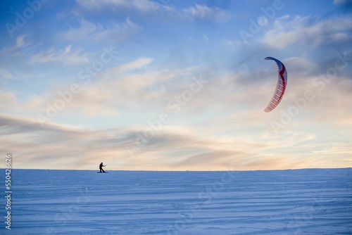 Scenic view of a single male snowkitting in the wide snow-covered surface photo