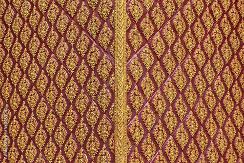 Golden pattern carved with beautiful Kanok designs on the walls of Thai temples.