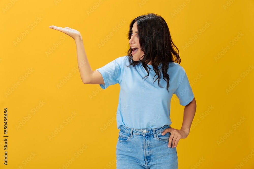 Woman signal smile with teeth emotion portrait in blue t-shirt on yellow background, hands up, surprise, lifestyle, copy space Woman signal smile with teeth emotion portrait in blue t-shirt on yellow background, hands up, surprise, lifestyle, copy space