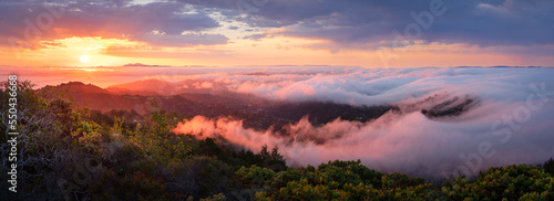 A colorful, dramatic sunrise over fog waves, viewed from Mt. Tamalpais, California.