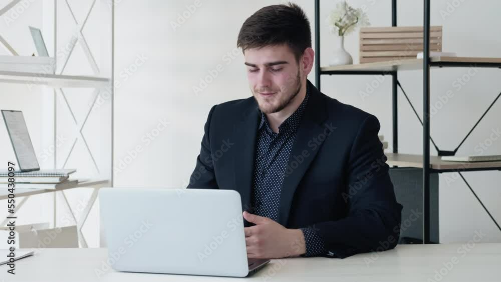 Online interview. Virtual meeting. Distance communication. Confident business man speaking using laptop at light modern digital office with free space. Long video shot. Online interview. Virtual meeting. Distance communication. Confident business man speaking using laptop at light modern digital office with free space. Long video shot.