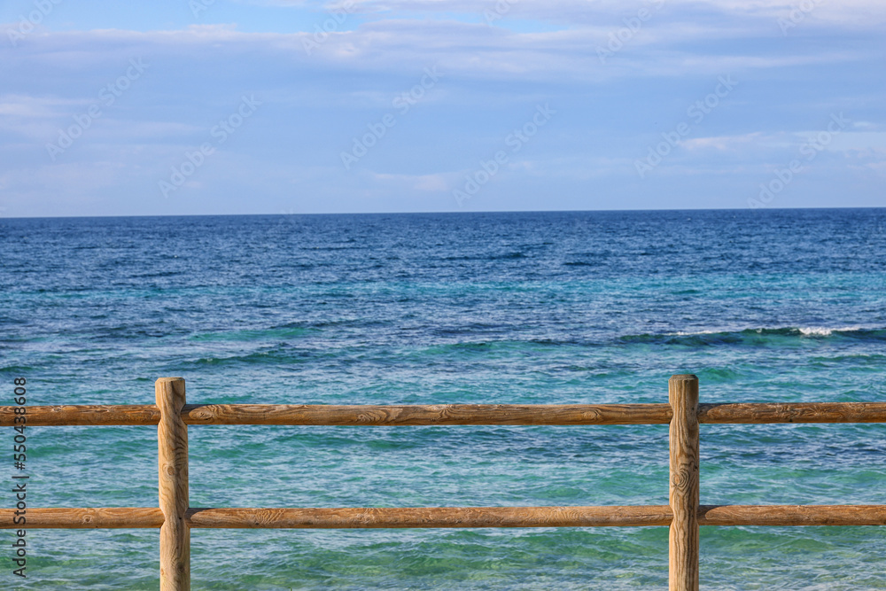 Beach by the sea with emerald green sea water and blue sky and white clouds. Summer vacation on tropical paradise beach concept. Ripple of water splash. Summer vibes. Beach by the sea with emerald green sea water and blue sky and white clouds. Summer vacation on tropical paradise beach concept. Ripple of water splash. Summer vibes.
