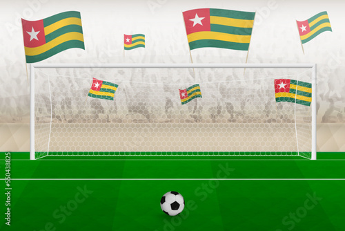 Togo football team fans with flags of Togo cheering on stadium, penalty kick concept in a soccer match.