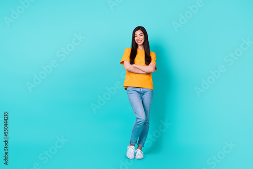 Full size photo of boss brunette lady crossed arms wear t-shirt jeans sneakers isolated on turquoise color background